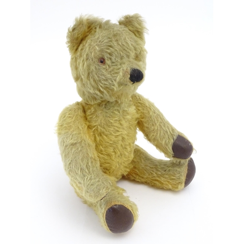 825 - Toy: A 20thC mohair teddy bear with stitched nose and mouth, pad paws and articulated limbs, a clock... 