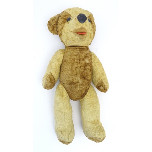 826 - Toy: A 20thC straw filled teddy bear with leather tongue and articulated limbs. Approx. 22 1/2