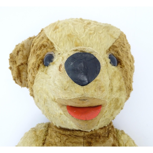 826 - Toy: A 20thC straw filled teddy bear with leather tongue and articulated limbs. Approx. 22 1/2