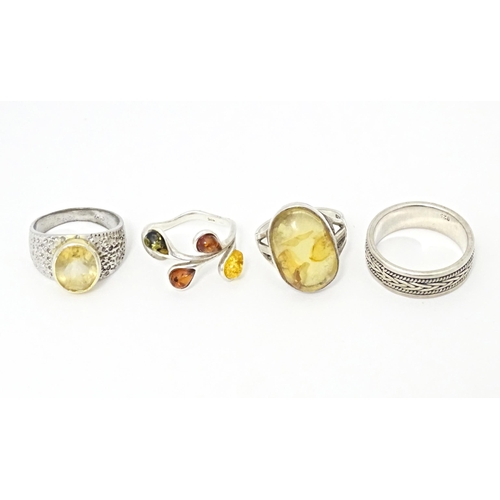 625 - Four various silver and white metal dress rings, some set with amber (4)