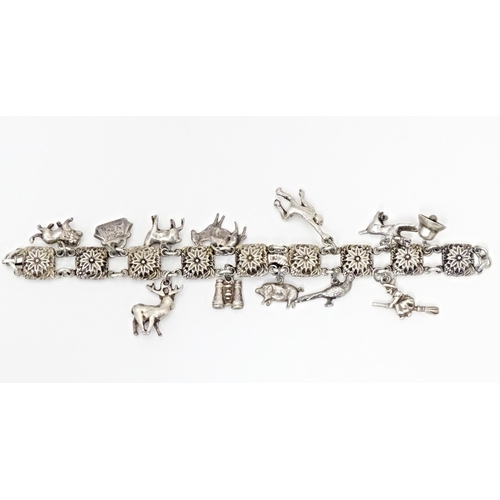 668 - A white metal bracelet set with 13 white metal charms. Approx 7 1/2