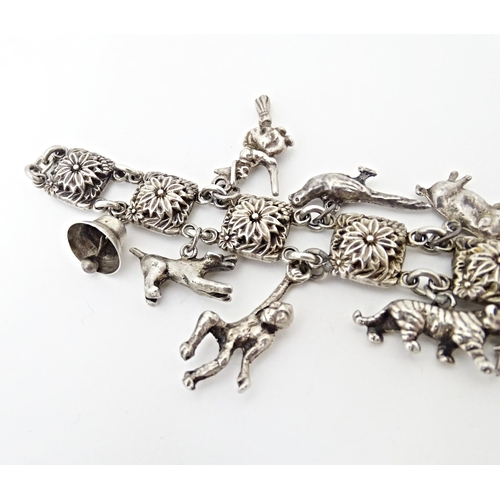 668 - A white metal bracelet set with 13 white metal charms. Approx 7 1/2