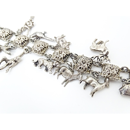 668 - A white metal bracelet set with 13 white metal charms. Approx 7 1/2