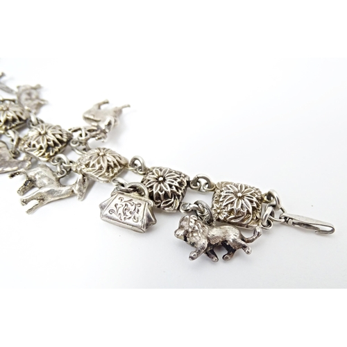 668 - A white metal bracelet set with 13 white metal charms. Approx 7 1/2