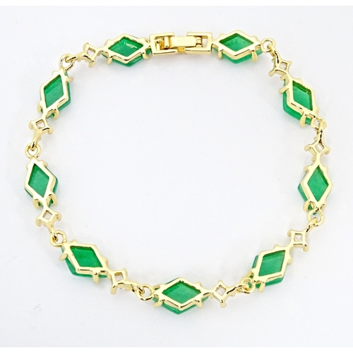 673 - A gilt metal bracelet set with jade green coloured stones and white stones. Approx 7 1/2