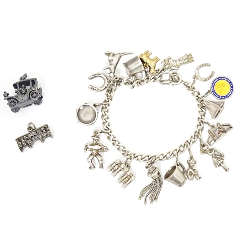 675 - A silver and white metal charm bracelet with various charms including a 9ct gold charm formed as a s... 