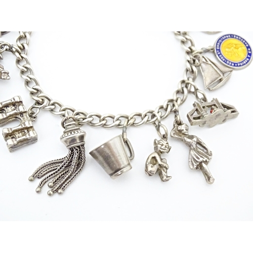 675 - A silver and white metal charm bracelet with various charms including a 9ct gold charm formed as a s... 