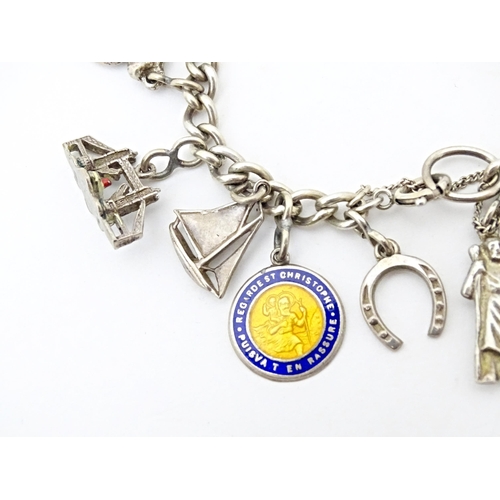 675 - A silver and white metal charm bracelet with various charms including a 9ct gold charm formed as a s... 