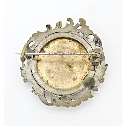 676 - A late 19thC / early 20thC brooch set with watercolour portrait to centre depicting a lady wearing a... 