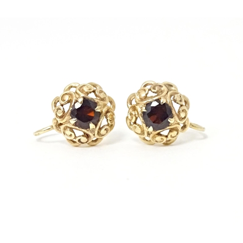 679 - 9ct gold earrings set with central garnets. Approx 1/4