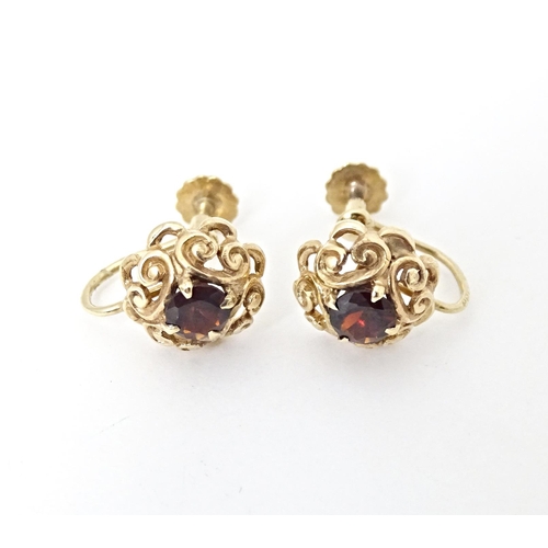 679 - 9ct gold earrings set with central garnets. Approx 1/4