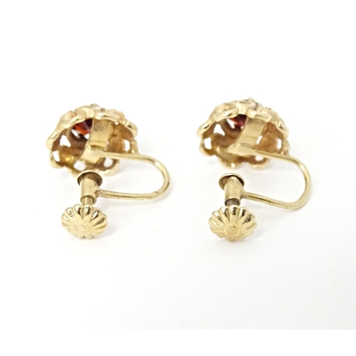 679 - 9ct gold earrings set with central garnets. Approx 1/4