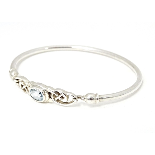 682 - A silver and white metal bangle formed bracelet set with aquamarine coloured stone