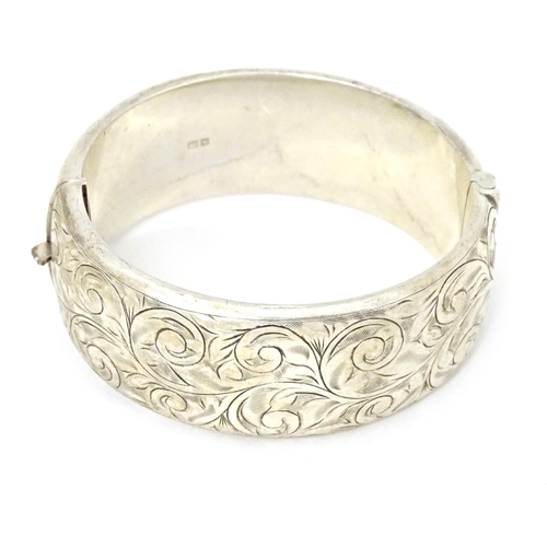 683 - A silver bracelet of bangle form with engraved acanthus scroll decoration. Hallmarked Birmingham 196... 