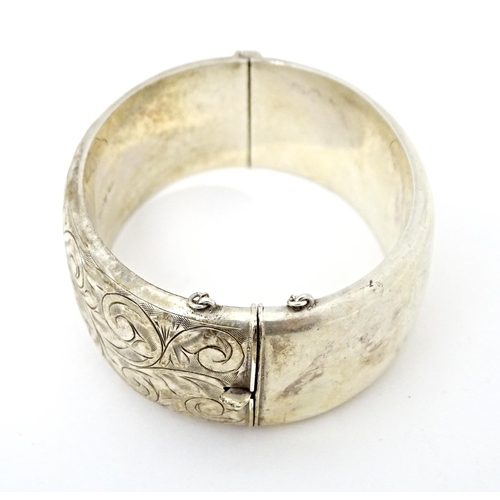 683 - A silver bracelet of bangle form with engraved acanthus scroll decoration. Hallmarked Birmingham 196... 