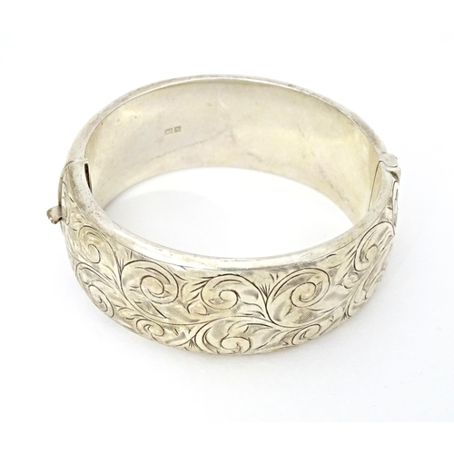 683 - A silver bracelet of bangle form with engraved acanthus scroll decoration. Hallmarked Birmingham 196... 