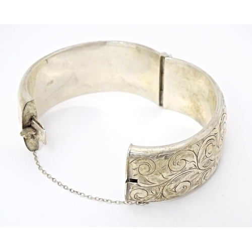 683 - A silver bracelet of bangle form with engraved acanthus scroll decoration. Hallmarked Birmingham 196... 