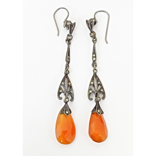 674 - A pair of white metal drop earrings set with marcasite and carnelian coloured facet cut drops. Appro... 