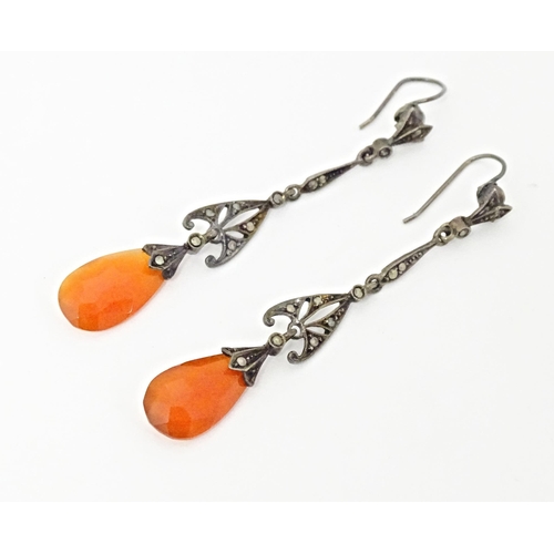 674 - A pair of white metal drop earrings set with marcasite and carnelian coloured facet cut drops. Appro... 