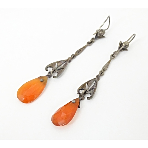 674 - A pair of white metal drop earrings set with marcasite and carnelian coloured facet cut drops. Appro... 