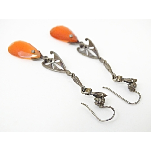 674 - A pair of white metal drop earrings set with marcasite and carnelian coloured facet cut drops. Appro... 