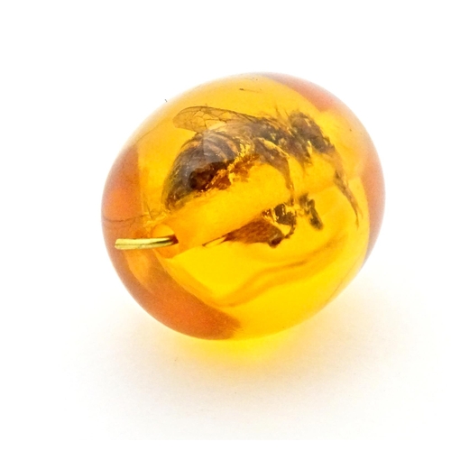 701 - A amber coloured copal style bead having insect within. 1