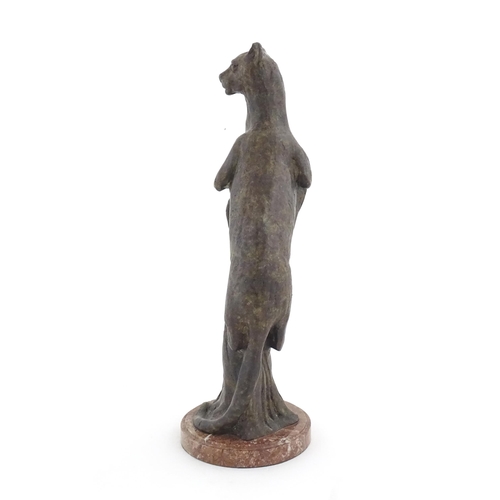 978 - A 20thC Continental cast patinated bronze model of a leopard / big cat on a styled tree stump. On a ... 