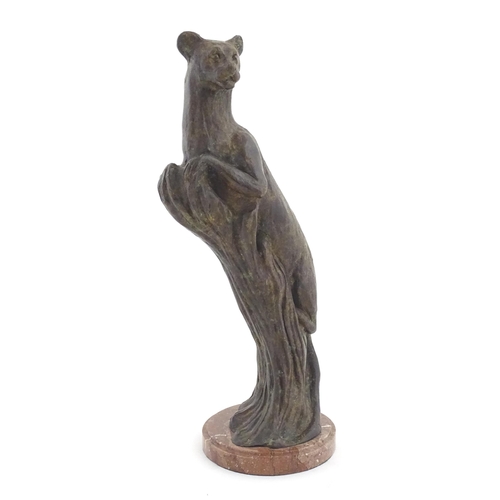 978 - A 20thC Continental cast patinated bronze model of a leopard / big cat on a styled tree stump. On a ... 