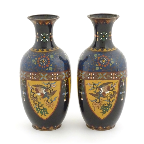 980 - A pair of Oriental cloisonne vases decorated with panels of dragons and phoenix birds, the shoulders... 