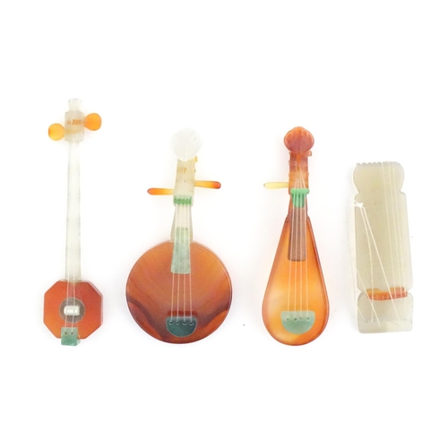 989 - Four Oriental agate models of musical instruments to include lute, quqin, etc. with wooden stands. L... 