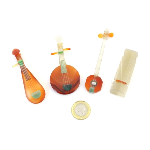 989 - Four Oriental agate models of musical instruments to include lute, quqin, etc. with wooden stands. L... 