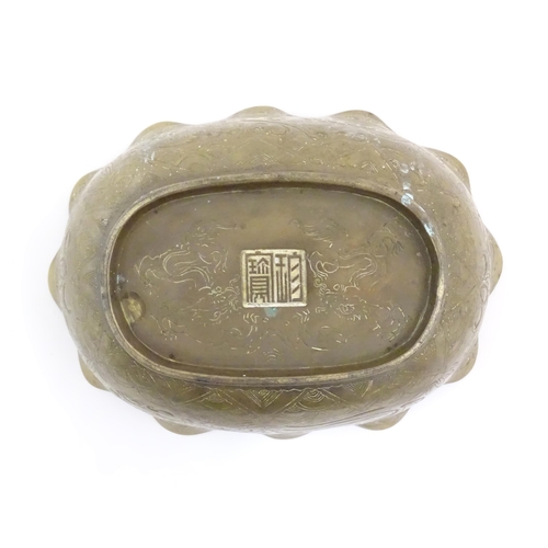 993 - A Chinese oval brass bowl with a lobed rim, decorated with incised dragons and flaming pearl amongst... 