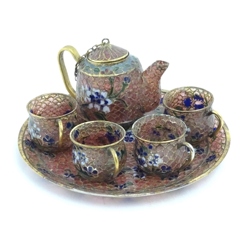 999 - A plique a jour miniature tea set comprising teapot, four cups and a circular tray, each decorated w... 