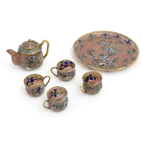 999 - A plique a jour miniature tea set comprising teapot, four cups and a circular tray, each decorated w... 