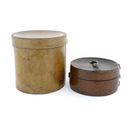 1030 - A 20thC leather collar box. Together with another leather muff box of cylindrical form. Largest appr... 