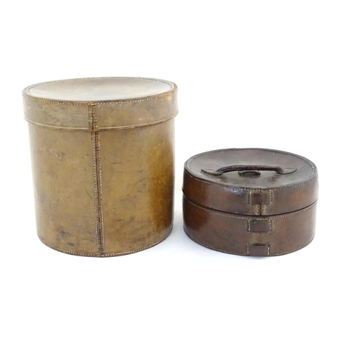 1030 - A 20thC leather collar box. Together with another leather muff box of cylindrical form. Largest appr... 