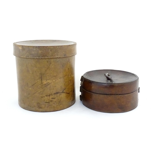 1030 - A 20thC leather collar box. Together with another leather muff box of cylindrical form. Largest appr... 