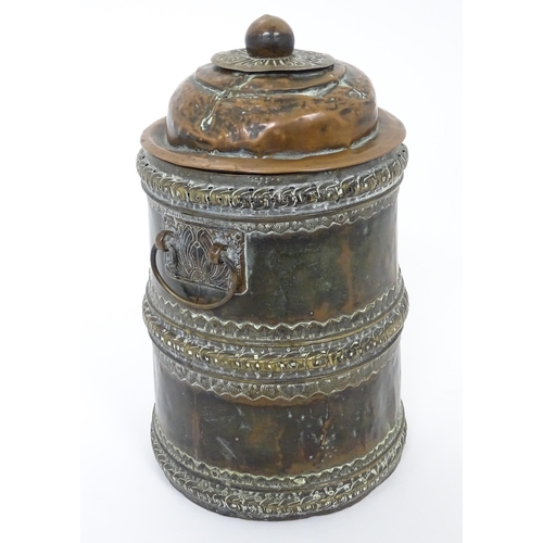 1056 - An Eastern copper lidded container of cylindrical form with twin handles, applied banded decoration ... 