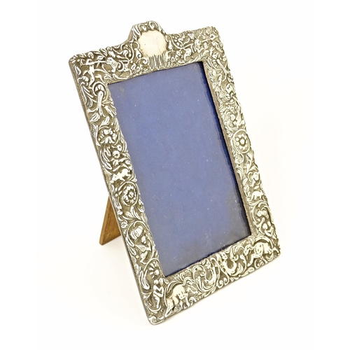 509 - An easel back photograph frame with an embossed silver surround hallmarked Birmingham 1899, maker De... 