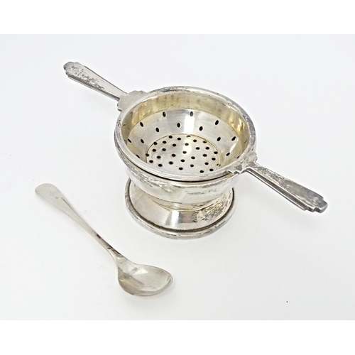 322 - An Art Deco style silver twin handled tea / lemon strainer with stand hallmarked Birmingham 1960, ma... 