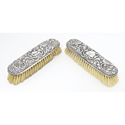 324 - Two silver backed brushes with embossed decoration, hallmarked Birmingham 1922, maker W. J. Myatt & ... 