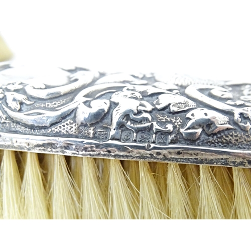 324 - Two silver backed brushes with embossed decoration, hallmarked Birmingham 1922, maker W. J. Myatt & ... 