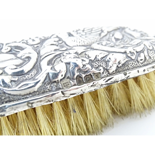 324 - Two silver backed brushes with embossed decoration, hallmarked Birmingham 1922, maker W. J. Myatt & ... 