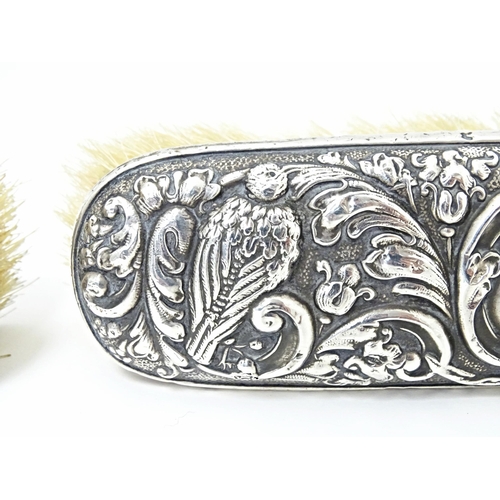 324 - Two silver backed brushes with embossed decoration, hallmarked Birmingham 1922, maker W. J. Myatt & ... 