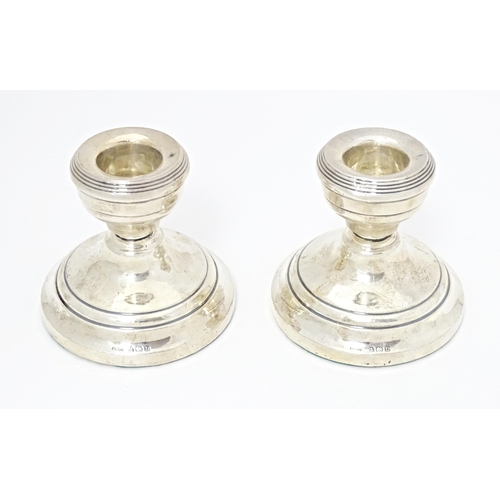 328 - A pair of short silver candlesticks hallmarked Birmingham 1928, maker Henry Clifford Davis. Approx. ... 