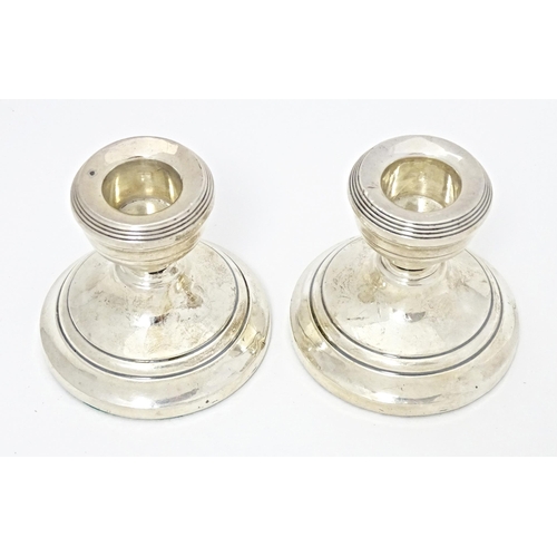 328 - A pair of short silver candlesticks hallmarked Birmingham 1928, maker Henry Clifford Davis. Approx. ... 