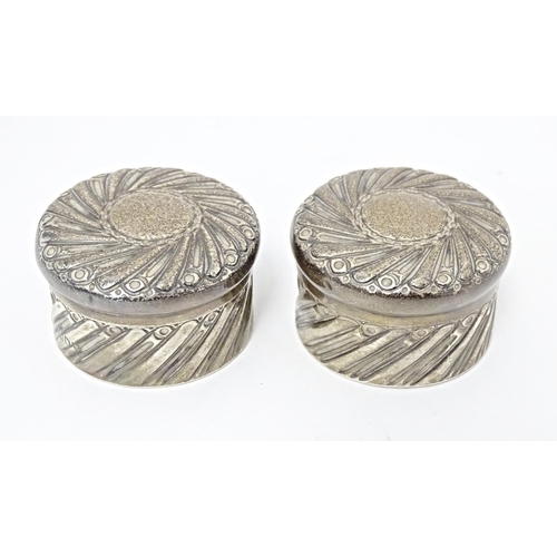 333 - A pair of Victorian silver pots and covers with embossed decoration hallmarked London 1892, maker Ch... 