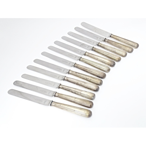 338 - A matched set of twelve Geo III and later silver handled table knives. Approx. 10 1/2