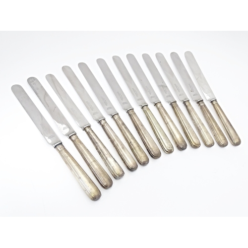 338 - A matched set of twelve Geo III and later silver handled table knives. Approx. 10 1/2