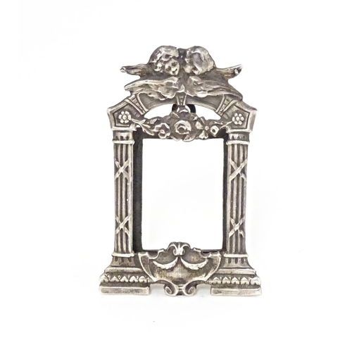 352 - A miniature silver frame with column and cherub detail, marked sterling. Approx. 1 3/4